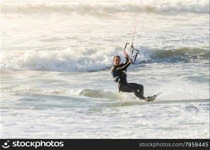 Kitesurfer in action on a beautiful background of spray during the sunset.