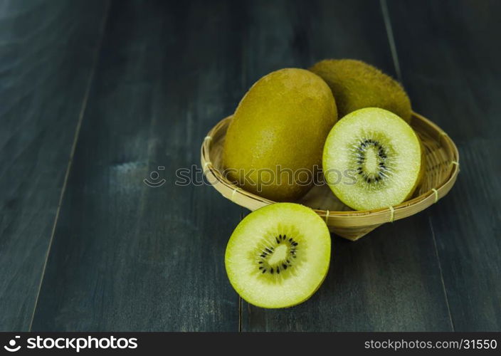 kiwi fruit and sliced with bamboo basket on wooden background , still life