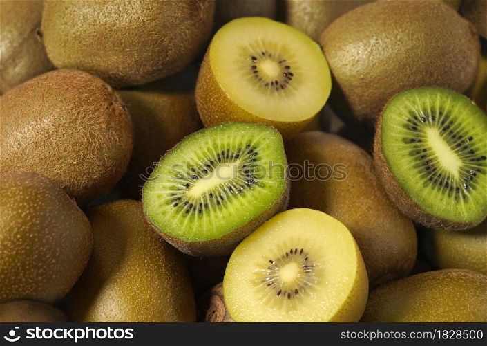 Kiwi fruit close up view of assorted fresh and juicy green and yellow kiwifruit as background.