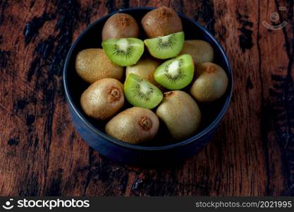 kiwi in a blue ceramic dish on an old wooden table