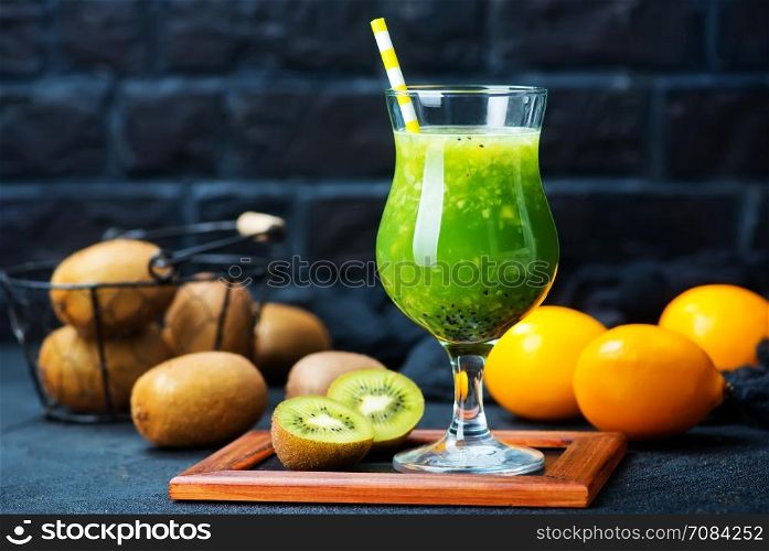 kiwi smoothie in glass and on a table