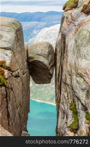 Kjeragbolten, the stone stuck between two rocks with fjord in the background, Lysefjord, Norway