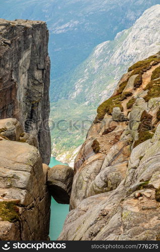 Kjeragbolten, view from the top to the stone stuck between two rocks with fjord in the background, Lysefjord, Norway