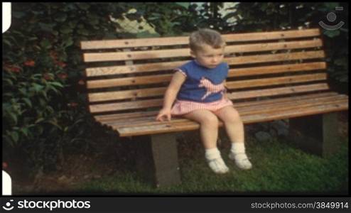Kleinkind sitzt auf einer Bank