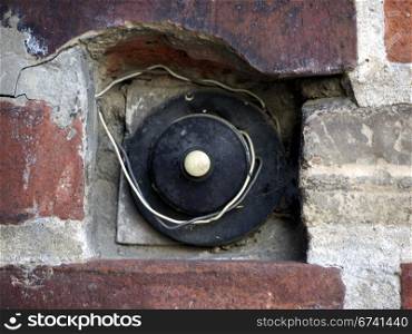 Klingel und Draht. Bell and wire on old brick wall