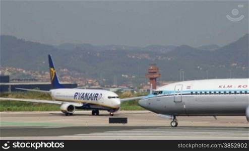 Klm and Ryanair aircrafts taxiing to the gate at Barcelona airport.Commercial airplanes ready for flight.Air crafts taking off at Barcelona Airport.Passenger airplanes speeding engines.