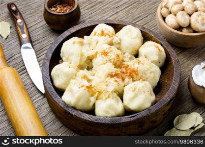 Knedliks, a boiled product made from dough, potatoes with mushroom filling on rustic the table. Potato dumplings with mushrooms, knedliki