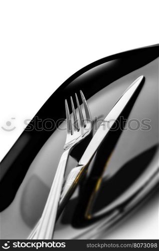 Knife and fork at plate on white background