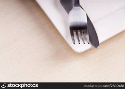 Knife and fork cutlery with a white place in very shallow focus