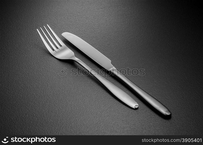 knife and fork on black