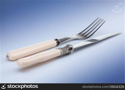 knife and fork on blue background. knife and fork on blue