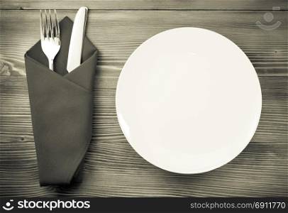 knife and fork with napkin on wooden background