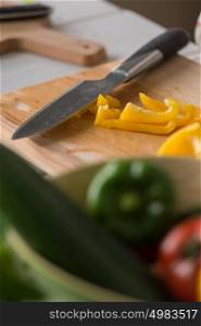 Knife and pepper on cutting board. Salad cooking