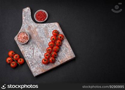 Knife, fork and cutting board, salt, pepper and other ingredients located on a textured concrete background