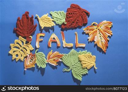 Knitted autumn leaves on blue textile