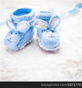 Knitted blue baby booties with rabbit muzzle for little boy. Knitted baby booties