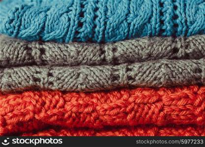 Knitted clothes stack close up as a background. Knitted clothes stack