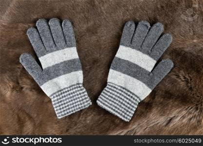 Knitted gloves on the background of fur