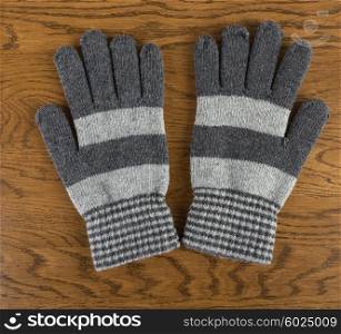 Knitted gloves on wooden background