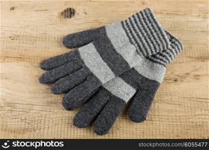 Knitted gloves on wooden background
