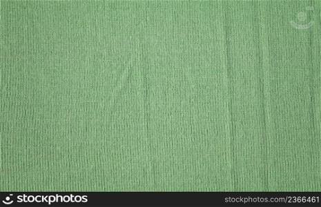 Knitted natural textile green sweater texture. Texture of a knitted eco green sweater wallpaper.. Cloth chlorine green backdrop with textured effect