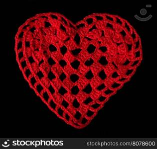 Knitted red heart made of yarn. Black isolated
