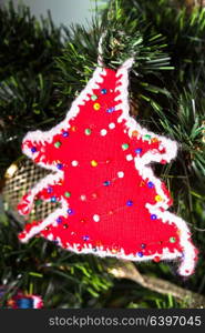 Knitted toy on Christmas tree, close up. Knitted toy on Christmas tree