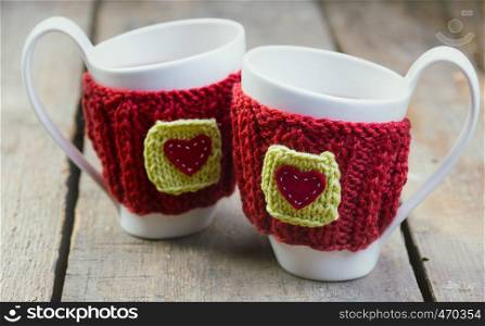 Knitted woolen cups on a wooden table