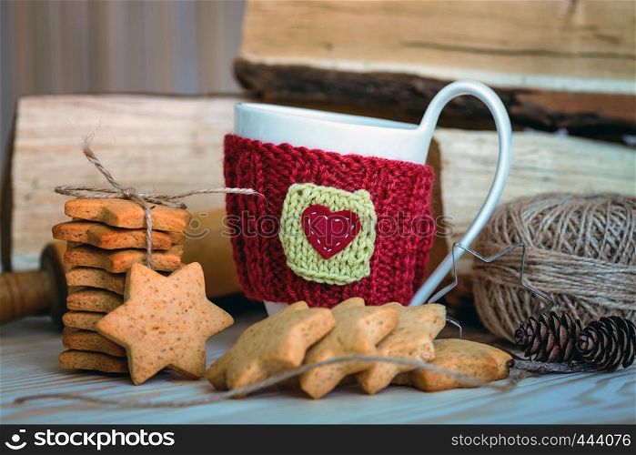 Knitted woolen cups on a wooden table and beautiful delicious christmas gingerbread