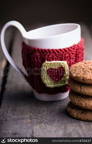 Knitted woolen cups on a wooden table, christmas
