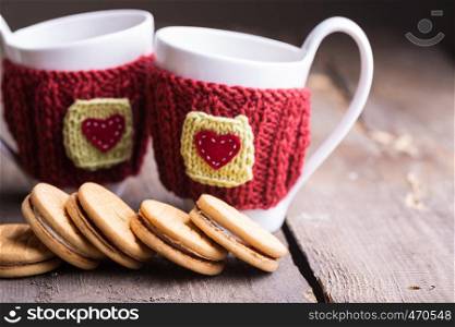 Knitted woolen cups on a wooden table, christmas