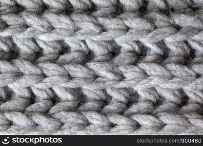 Knitted woolen textured surface, macro. Soft grey merino wool pattern backdrop, closeup. Autumn and winter flat lay. Scandinavian minimal style.