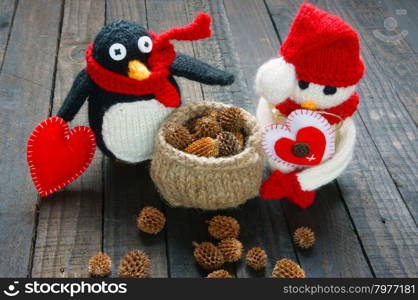 Knitted Xmas ornament, handmade snowman, hand made penguin knit from red, white wool, this toy for christmas holiday, abstract background with pine cone, gift card, red heart