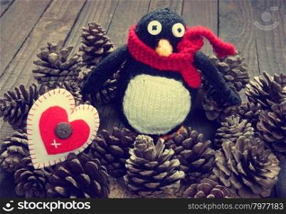Knitted Xmas ornament, handmade snowman, hand made penguin knit from red, white wool, this toy for christmas holiday, abstract background with pine cone, gift card, red heart