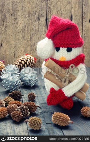 Knitted Xmas ornament, handmade snowman, hand made penguin knit from red, white wool, this toy for christmas holiday, abstract background with pine cone, gift card, red heart