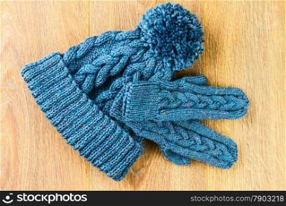 knitting cap and mittens on wooden background