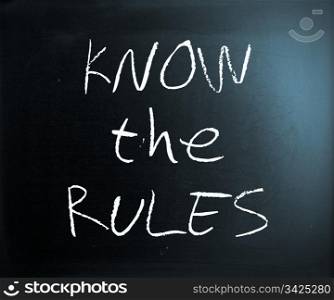 ""Know the rules" handwritten with white chalk on a blackboard."