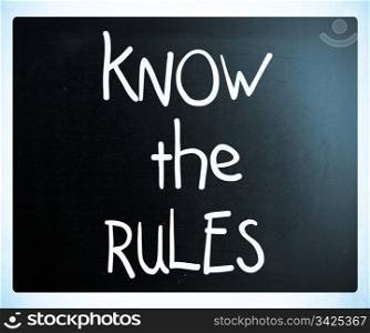 ""Know the rules" handwritten with white chalk on a blackboard"