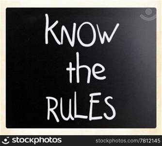 ""Know the rules" handwritten with white chalk on a blackboard"