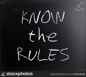 ""Know the rules" handwritten with white chalk on a blackboard."