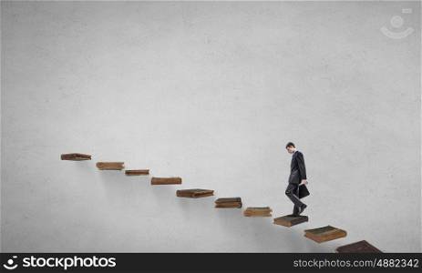 Knowledge as key to success. Businessman walking on career ladder made of books