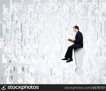 Knowledge concept. Businessman with book sitting on top of exclamation mark