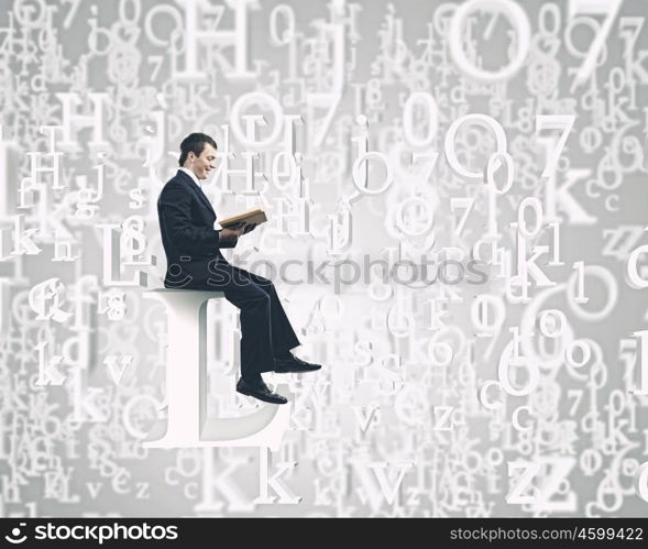 Knowledge concept. Businessman with book sitting on top of huge letter