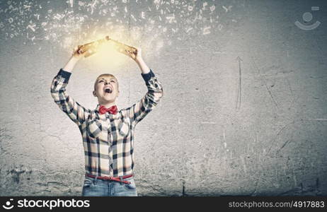 Knowledge concept. Young woman in shirt holding book above head