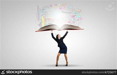 Knowledge is power. Young businesswoman in paper crown lifting books above head