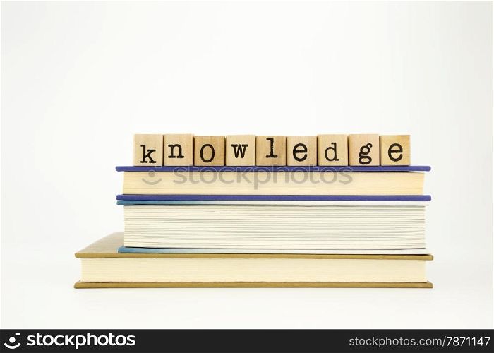 knowledge word on wood stamps stack on books, academic and study concept
