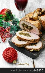 Knuckle meat for Christmas. Dish of roulade of veal stuffed with mushrooms and spices and Christmas decorations