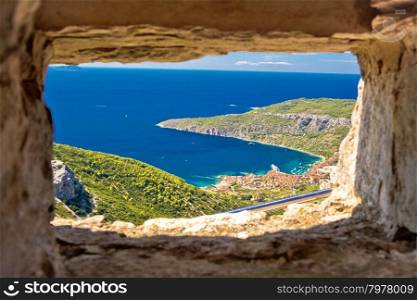 Komiza bay aerial view through stone window from Island of Vis hill, Dalmatia, Croatia