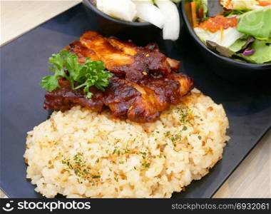 Korean food. Fried rice with roasted honey and sesame glazed chicken served with salad.