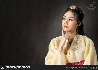 Korean woman wearing traditional korean dress (Hanbok) on black background in studio. Beautiful Korea culture.